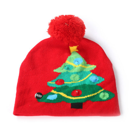 Red beanie with a Christmas tree design, featuring colorful ornaments and a yellow garland, topped with a fluffy red pom-pom and a small "On/Off" button on the bottom left.