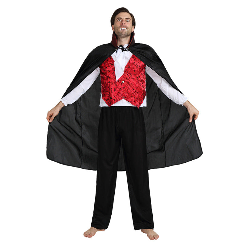 Man dressed as a vampire wearing a black cape, red vest, white shirt, and black pants. He is barefoot and showing fangs, posing with the cape spread open.