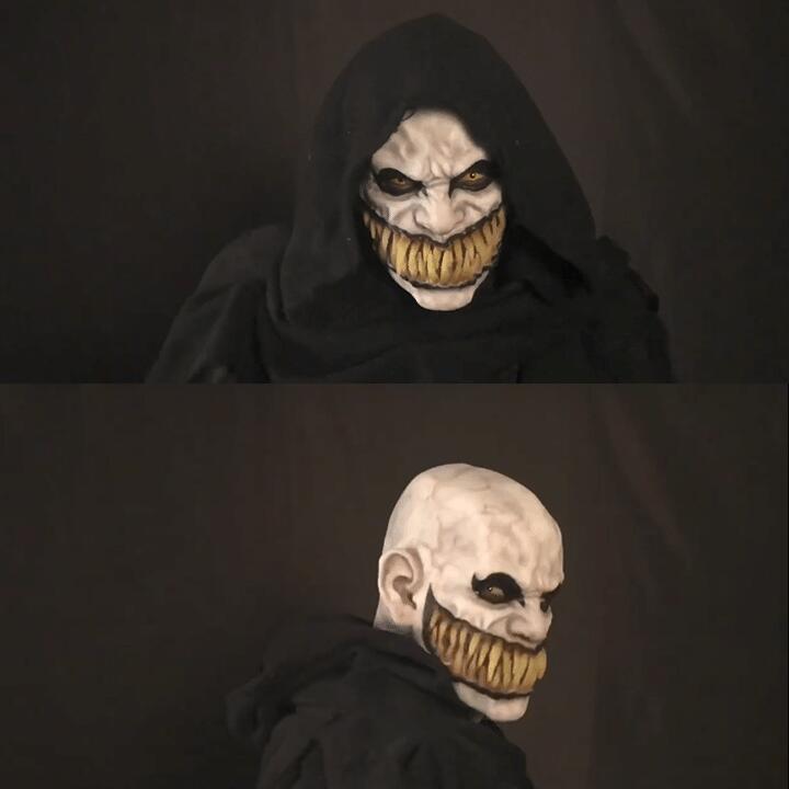 A person in a sinister, detailed mask featuring a wide yellow grin and intense eyes. They wear a black hooded cloak, with front and side views displayed.