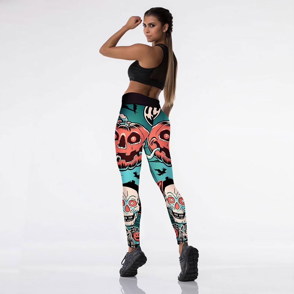 Woman in a sporty pose wearing Halloween-themed leggings with pumpkin and skull designs. She has long hair and a black sports bra against a plain white background.