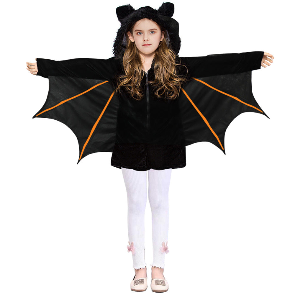 Child in a black bat costume with spread wings, wearing a hood with ears and white leggings adorned with flowers, standing against a white background.