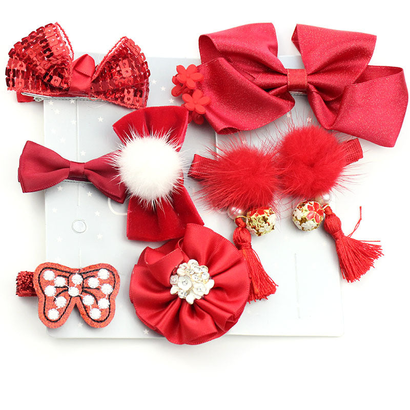 A collection of eight red hair accessories, including bows with sequins, fur, and tassels, arranged on a light background. One features white beads and a flower design.