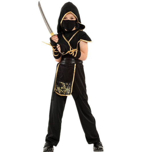 Child dressed as a ninja in a black and gold costume, holding a sword. The outfit includes a hood, mask, and detailed patterns on the tunic skirt against a white background.