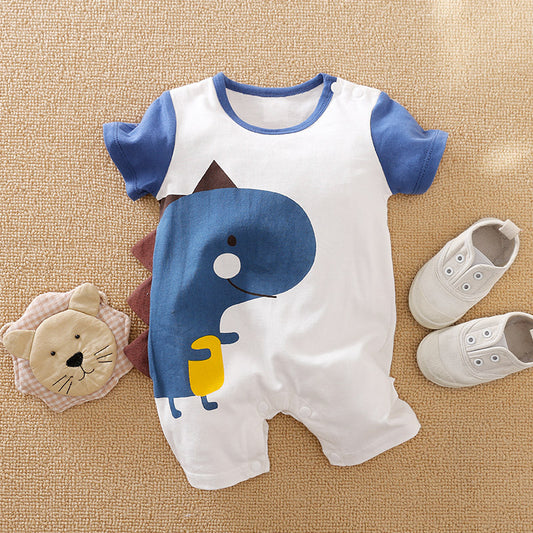 Baby romper with a blue dinosaur design and blue sleeves, paired with small white shoes. A plush lion face toy lies to the left, all on a beige carpet.