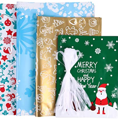 Four rolls of festive wrapping paper feature Christmas designs: red and white stars, blue snowflakes, gold with line drawings, and green with Santa and "Merry Christmas" text.