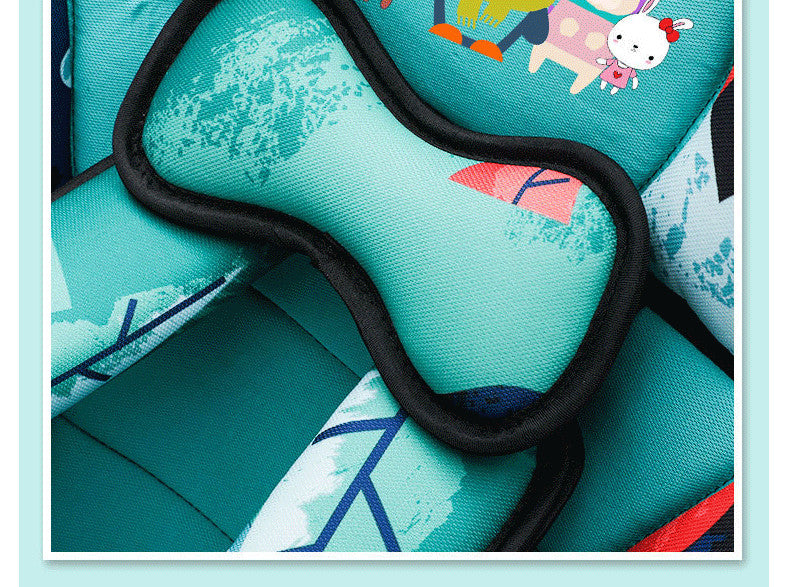 Close-up of a colorful cushioned fabric with abstract patterns and cartoon characters. A black U-shaped trim outlines parts of the design.
