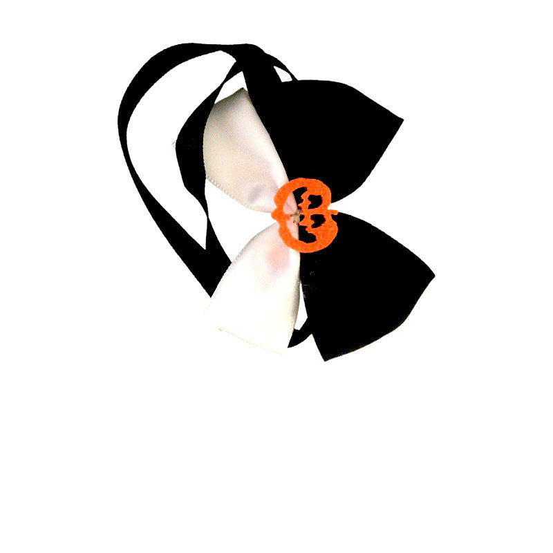 Black and white bowtie with a black band, featuring an orange pumpkin face decoration at the center.