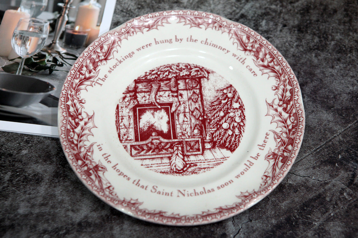 Vintage plate with a red illustration of a fireplace and stockings, bordered by holly leaves. Inscription reads, “The stockings were hung by the chimney with care...”