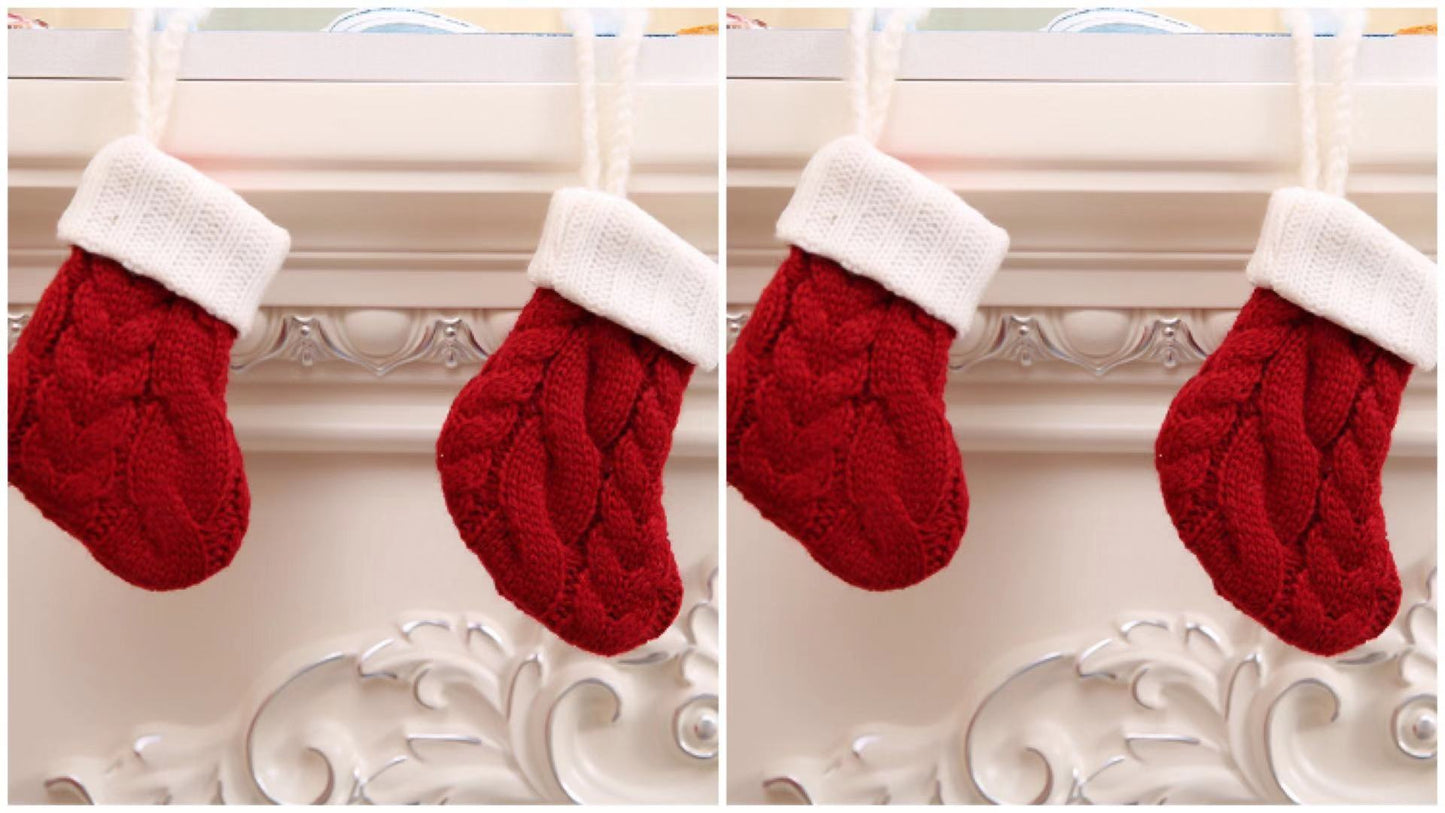 Two red knit Christmas stockings with white cuffs hang on a carved white mantle.