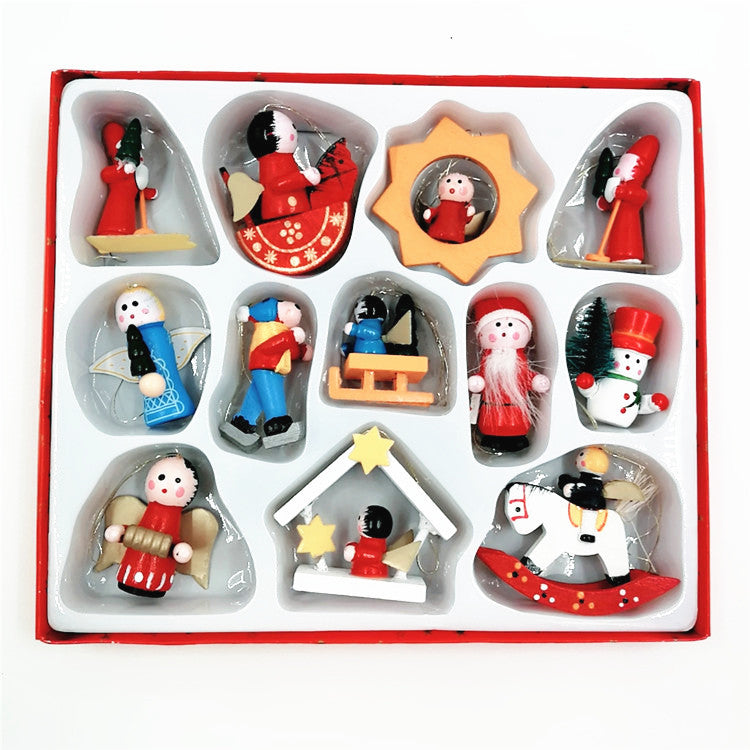 Box of 12 decorative wooden Christmas ornaments including angels, Santa, snowman, rocking horse, and winter figures. All are arranged neatly in a red-trimmed display case.