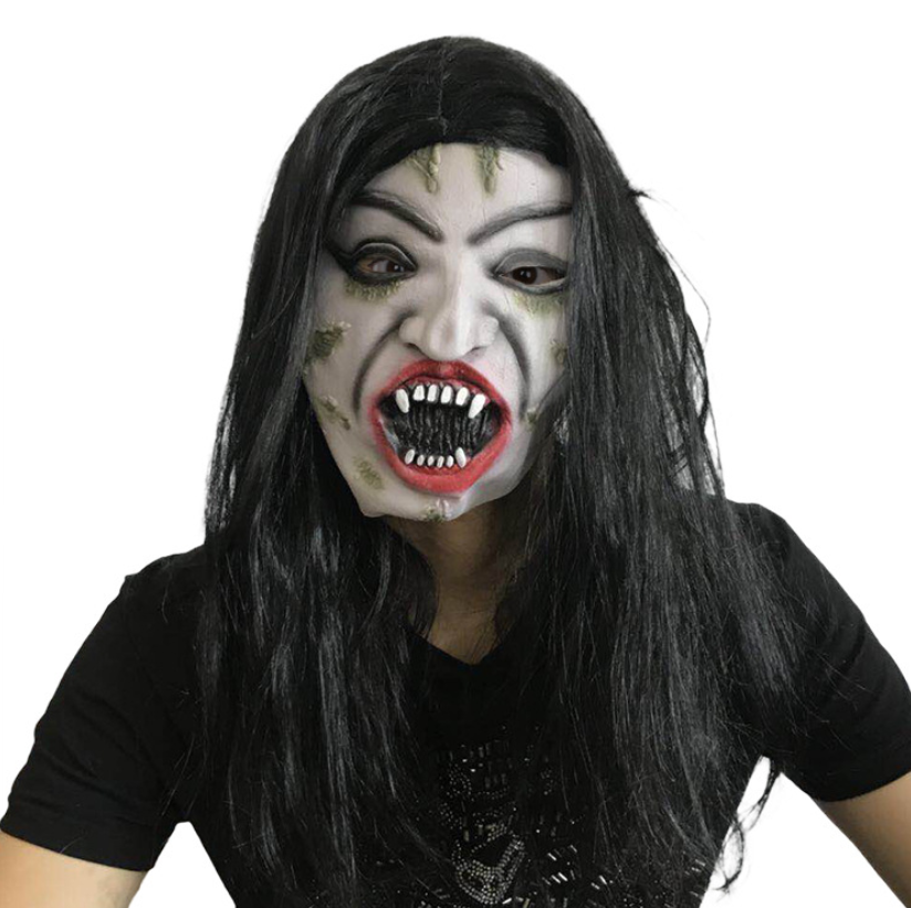Person wearing a horror mask with long black hair and exaggerated features including sharp teeth and red lips, set against a plain white background.