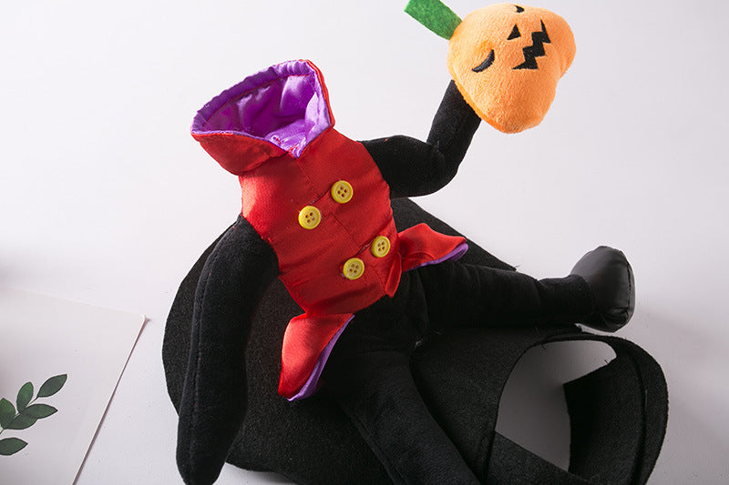 A headless plush figure in a red and black outfit with yellow buttons holds a pumpkin with a jack-o'-lantern face. The toy lies on a black surface with a light background.