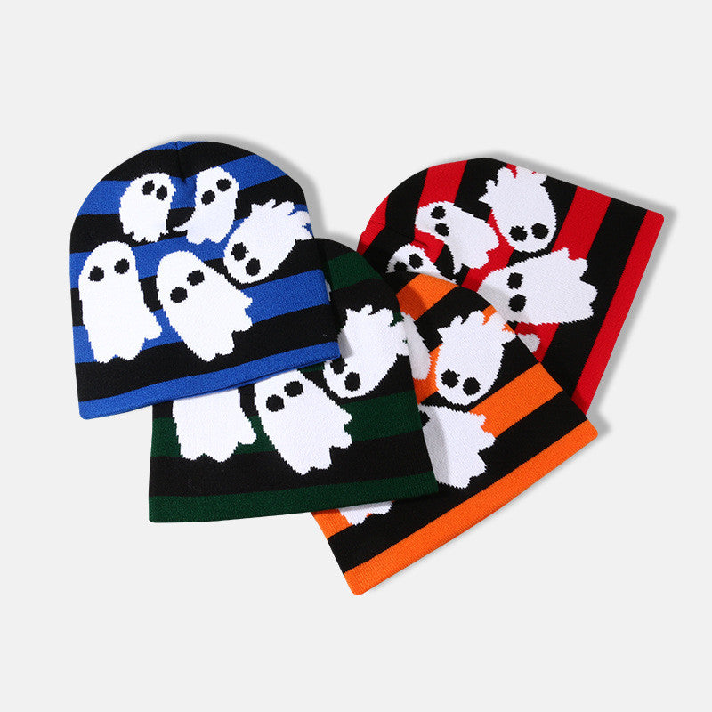 Four striped beanies with cartoon ghost designs. Colors include blue, green, orange, and red, each with black stripes and white ghost patterns. Laid out overlapping on a plain background.