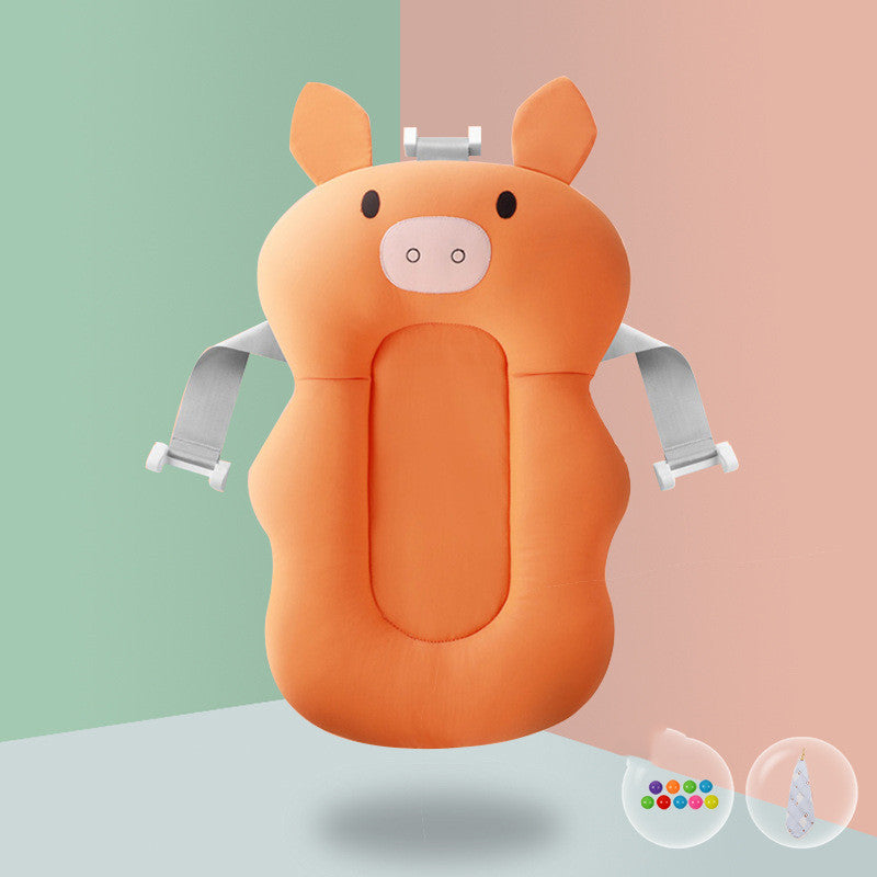 Cute orange pig-shaped baby bath cushion with safety straps on a green and pink split background. Small icons of a colorful ball and a droplet are visible below.