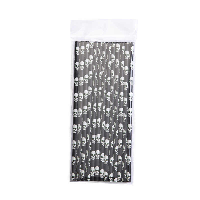 A pack of black paper straws featuring a white skull pattern, neatly arranged in a clear plastic bag with a white top edge.
