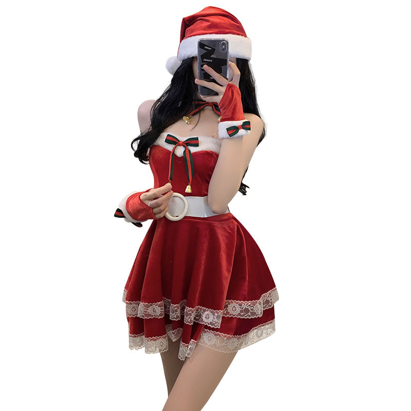 Woman in a red Santa-themed dress with lace trim and matching hat, taking a mirror selfie. The outfit features bows and a large white belt, accessorized with wristbands.