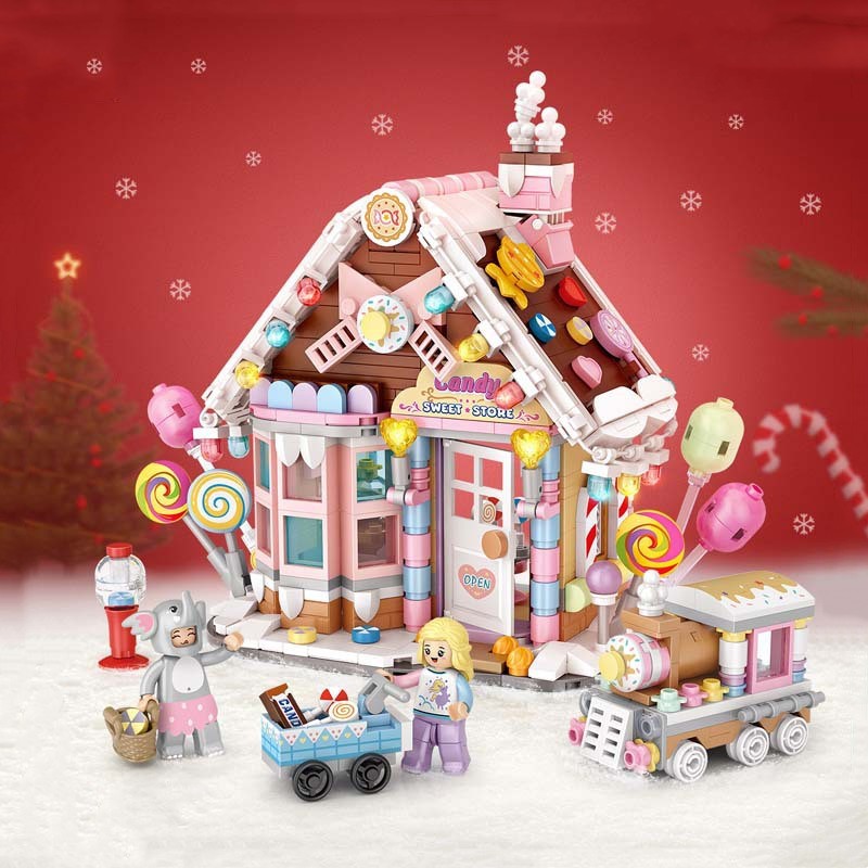 Toy candy store with colorful decorations, set in a snowy scene. Includes two toy figures, a cart of sweets, and a small toy train. Background features a Christmas tree and candy canes.