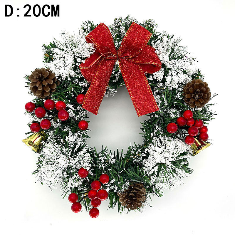 Festive wreath with a red bow, pinecones, red berries, golden bells, and snow-dusted greenery. The diameter is 20 cm, creating a classic holiday decoration.