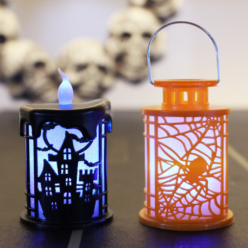 Two decorative Halloween lanterns with lit interiors. The left lantern is black with a haunted castle design and emits a blue light. The right lantern is orange with a spider web pattern, glowing white. In the background, a garland of white skulls is slightly blurred.