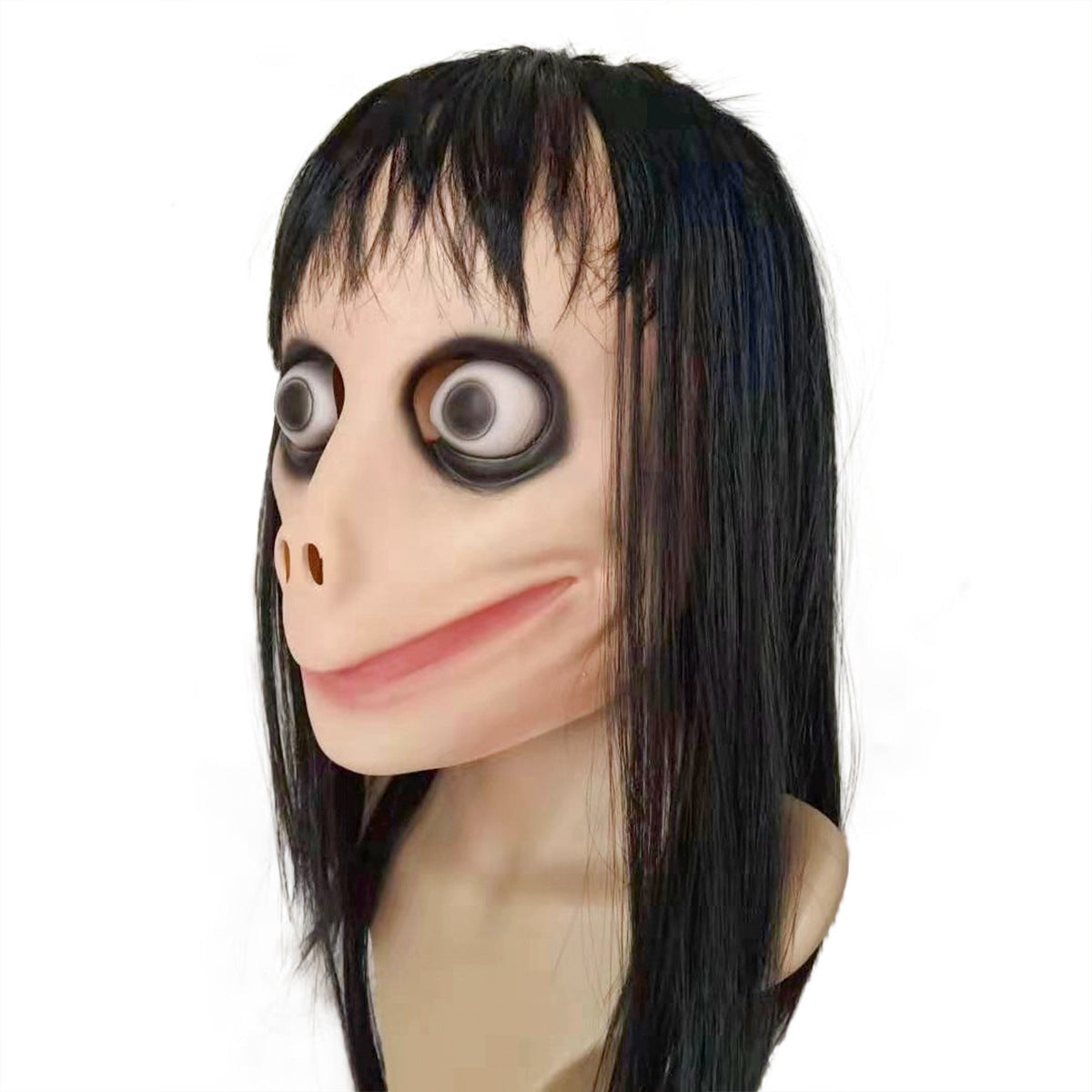 A sculpture with a distorted human face, featuring large, bulging eyes, a wide grin, and long black hair. The expression is eerie, set against a plain white background.