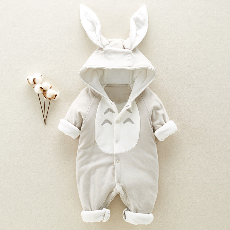 Baby onesie with bunny ear hood, featuring a cartoon face on the chest, buttoned front, and roll-up cuffs, laid on a neutral background with cotton plant accents.