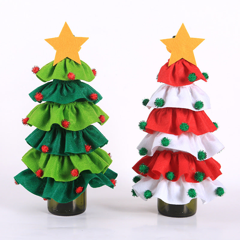 Two decorative Christmas trees made from layered fabric ruffles on bottle bases. One is green with red pompoms, the other red and white with green pompoms, both topped with yellow stars.