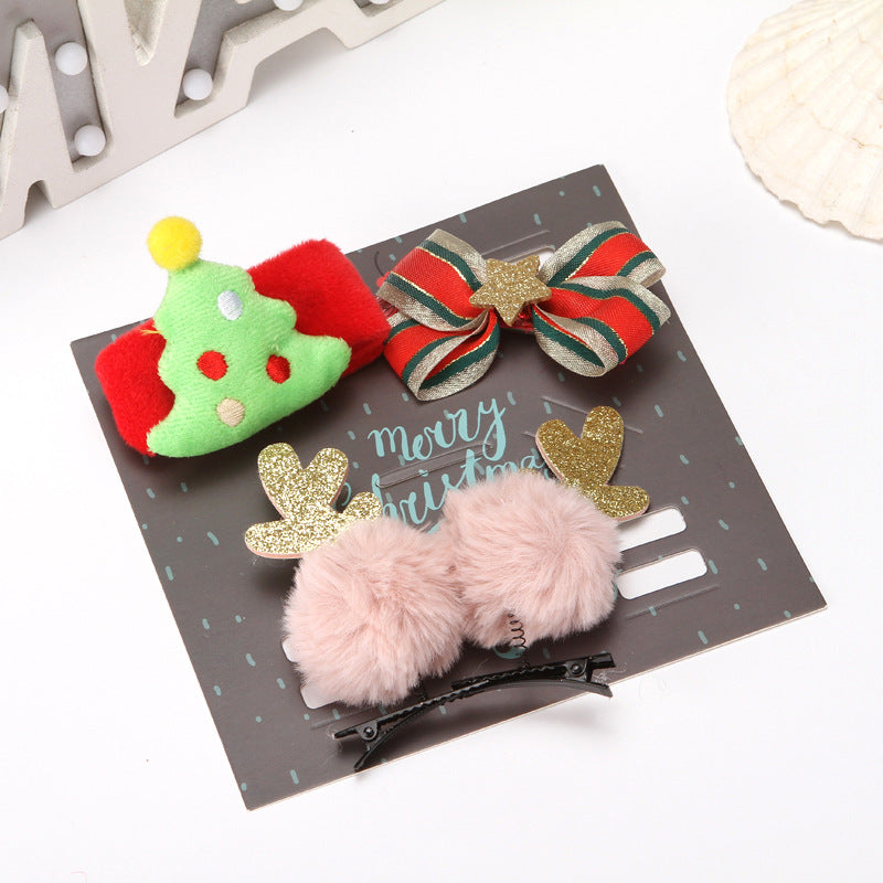 Festive hair clips set: a Christmas tree, a striped bow with a star, and reindeer pom-poms on a "Merry Christmas" card.