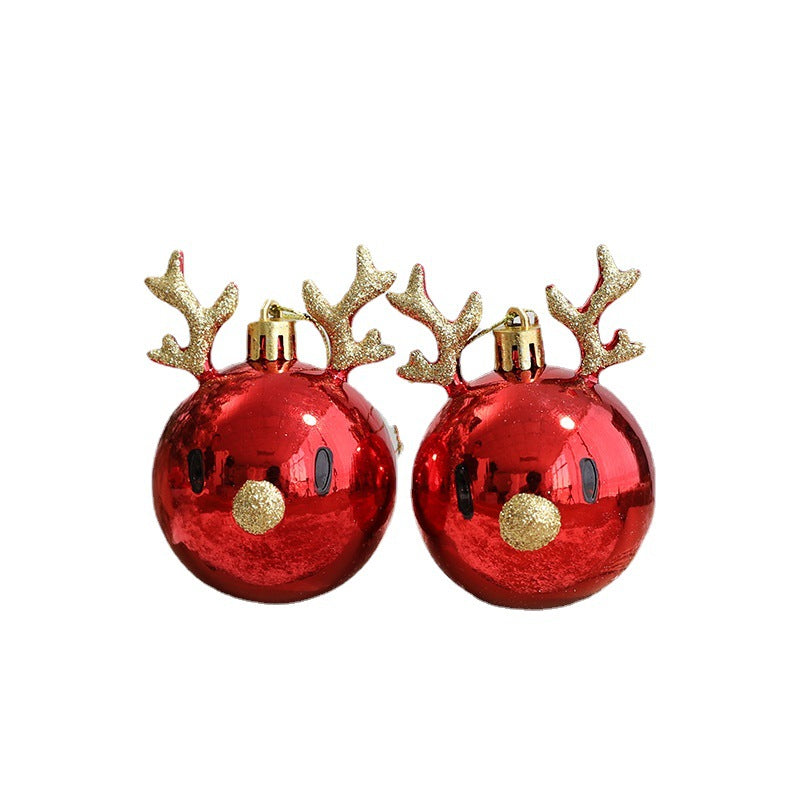 Two shiny red Christmas baubles with gold glitter antlers and noses, resembling reindeer faces.