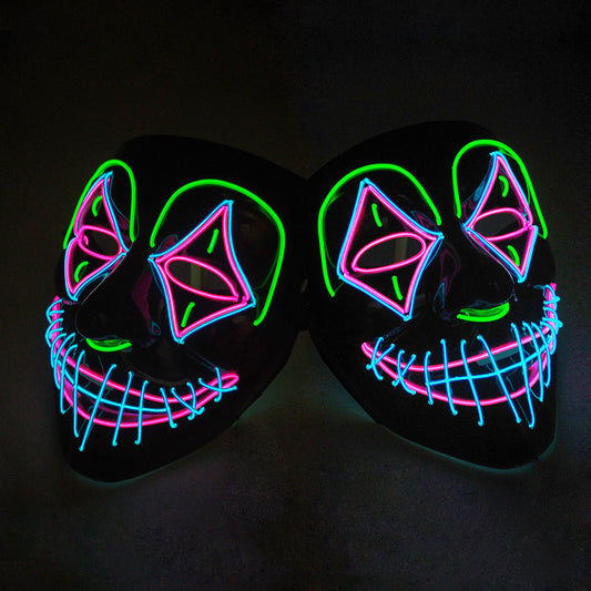Two black masks with neon outlines form colorful faces. The designs feature green, pink, and blue wires outlining eyes, nose, and a jagged smile, creating an eerie, glowing effect.