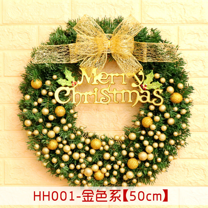 A festive Christmas wreath with gold ornaments, a large shimmering bow, and "Merry Christmas" sign, set against a light brick wall. Text reads "HH001-Gold Series [50cm]."