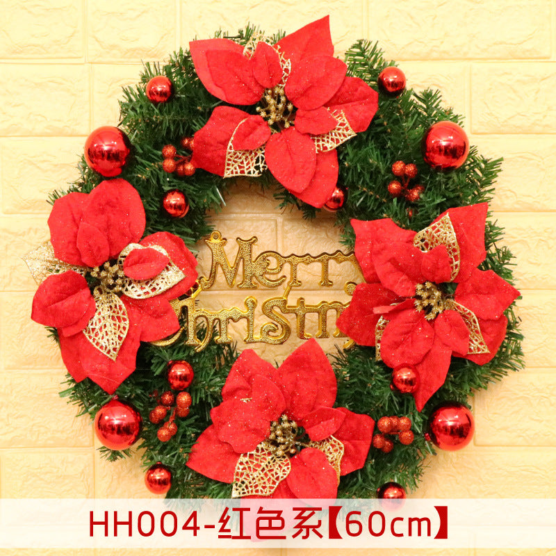 Festive Christmas wreath with red poinsettias, gold accents, and baubles. The centerpiece reads "Merry Christmas." Set against a light brick wall. Measurements indicate 60 cm.