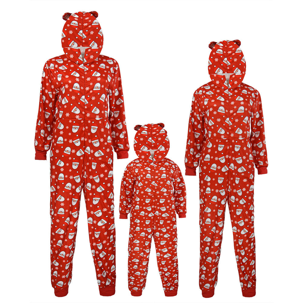 Red family Christmas onesies with white holiday patterns and bear-eared hoods. Three sizes are shown: two adult and one child. The fabric has a festive winter print.