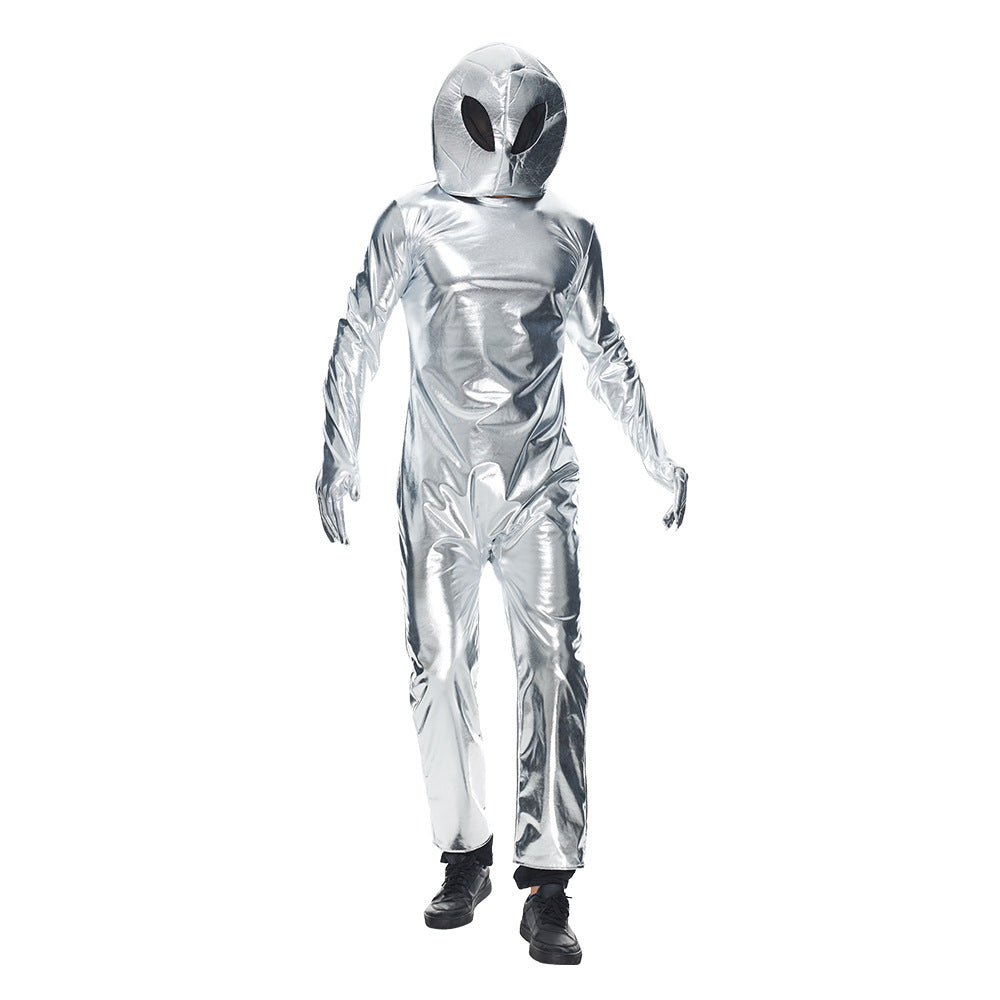Person dressed in a shiny silver alien costume with a large head and black oval eyes, standing against a white background. The outfit is a full-body suit with matching gloves and black shoes, creating an extraterrestrial appearance.