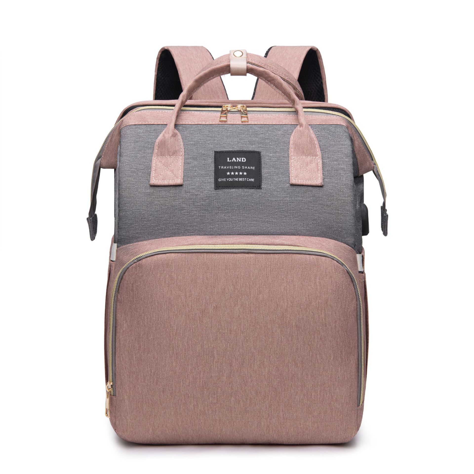 Stylish two-tone backpack in pink and gray with a front pocket, zipper closure, top handle, and adjustable padded straps. Features a label with text and logo on the front.