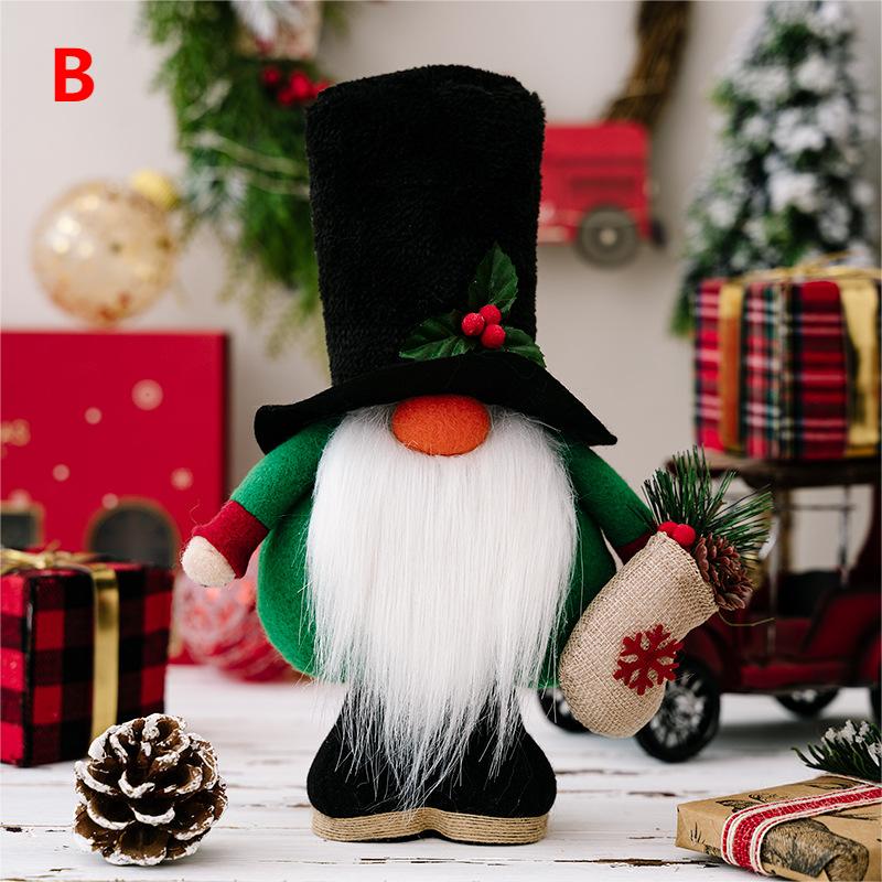 A plush Christmas gnome with a tall black hat and bushy white beard holds a sack. It's surrounded by wrapped gifts, a pinecone, and festive decor, including a wreath.