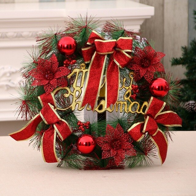 Festive Christmas wreath with red bows, ornaments, artificial poinsettias, and green foliage. A "Merry Christmas" sign is elegantly placed at the center.