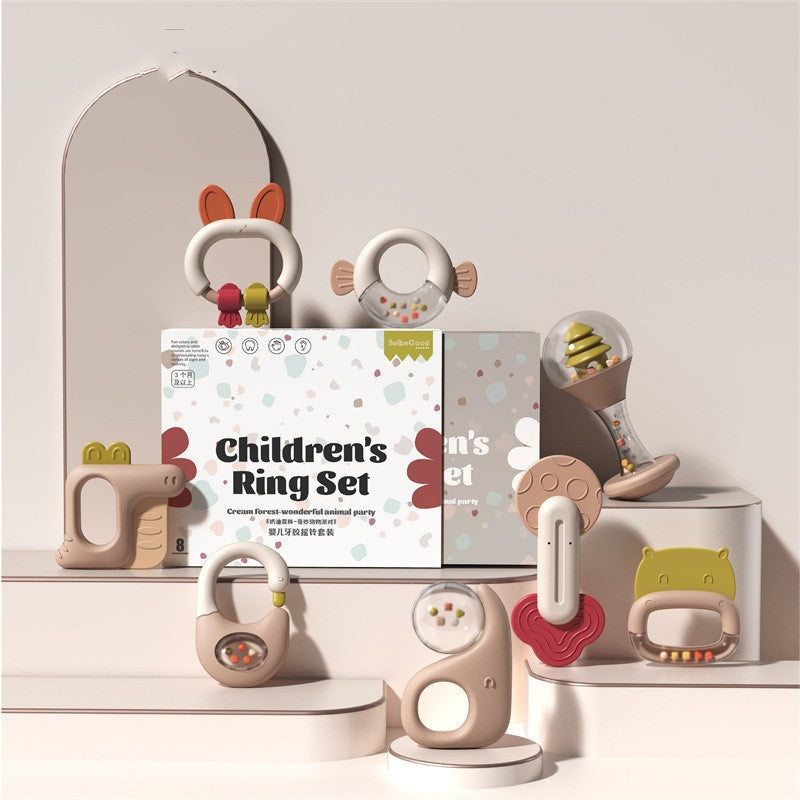 Children's Ring Set with cute animal-themed designs. Includes various pastel-colored baby rattle toys on a white display, with packaging in the background.