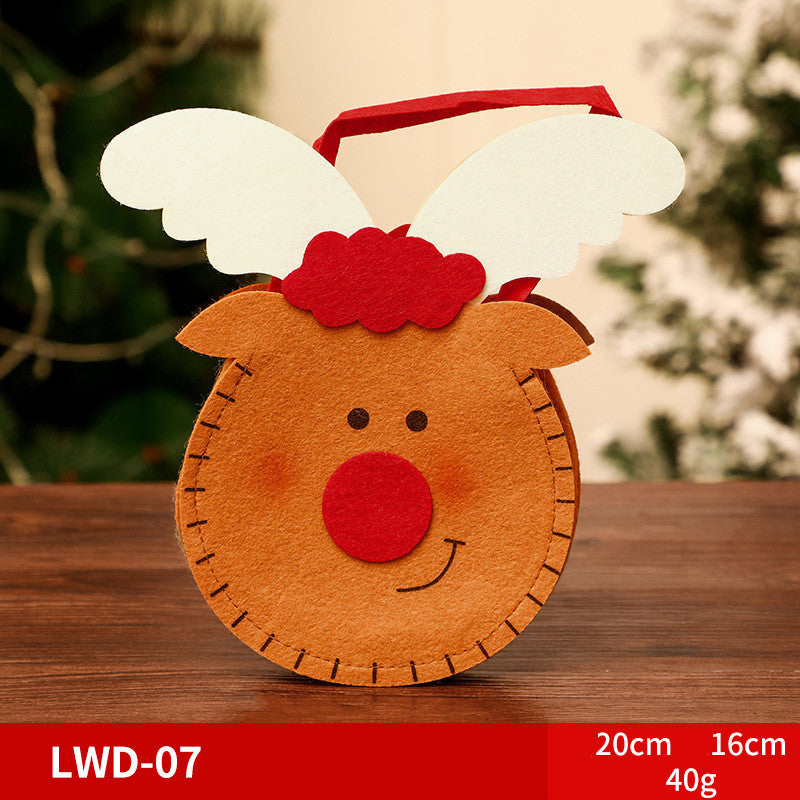 Felt bag shaped like a smiling reindeer with a red nose and white antlers. It's placed on a wooden table with a blurred green background. Dimensions: 20cm x 16cm, 40g.