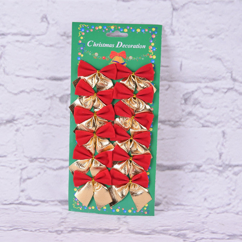 Pack of red and gold bow Christmas decorations on a green card. Labeled "Christmas Decoration" with festive graphics. Background is a white brick wall.
