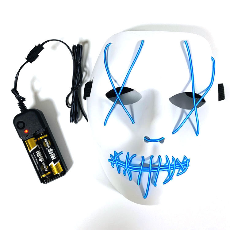 White mask with blue LED wires forming stitched patterns over the eyes and mouth, connected to a black battery pack with two AAA batteries and a control switch.
