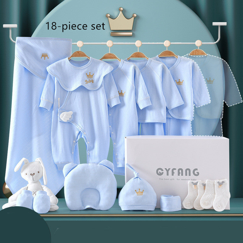 Blue baby clothing set displayed on hangers includes onesies, pajamas, a hat, socks, and a blanket, accompanied by a plush toy. A gift box and crown icon complete the 18-piece set.