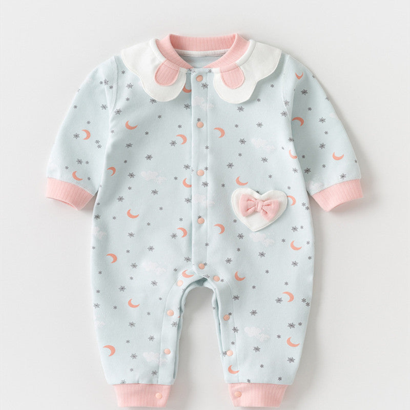 Light blue baby onesie with moon and star pattern, pink cuffs, and scalloped white collar. Features a heart-shaped patch with a pink bow on the front.