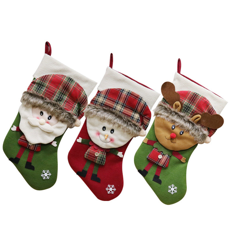Three festive Christmas stockings with plush designs: Santa, a snowman, and a reindeer, each wearing plaid hats and decorated with faux fur trims and snowflake patterns.