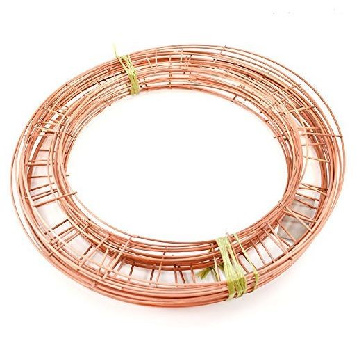 A coiled bundle of copper wire secured with green ties on a white background. The wire appears shiny and smooth, arranged in a circular shape.