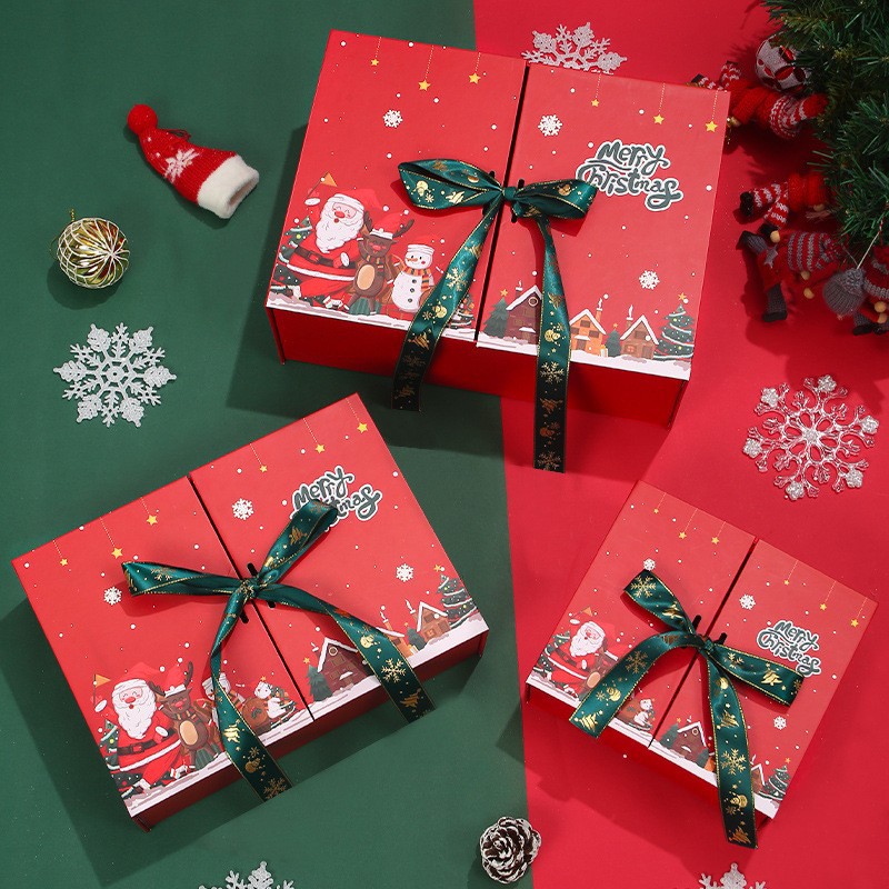 Three red Christmas gift boxes with green ribbons are adorned with Santa and snowman illustrations. They rest on a red and green background with festive decorations.