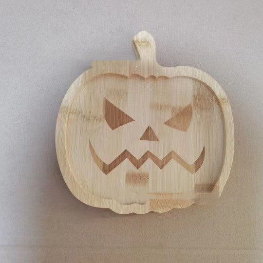 Wooden pumpkin-shaped tray with a carved Jack-o'-lantern face, featuring triangular eyes and a jagged mouth, against a neutral background.
