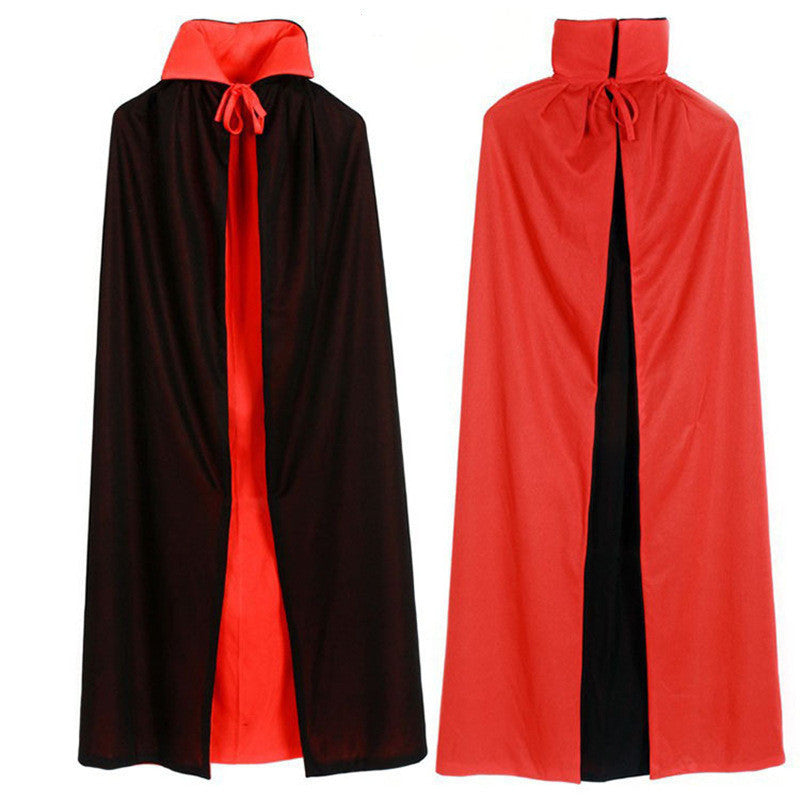 Two reversible capes are displayed. The first cape is black on the outside and red on the inside, fastened with a red tie at the neck. The second cape is red on the outside and black on the inside, also with a red tie closure. Both capes have high collars and reach below the knees.