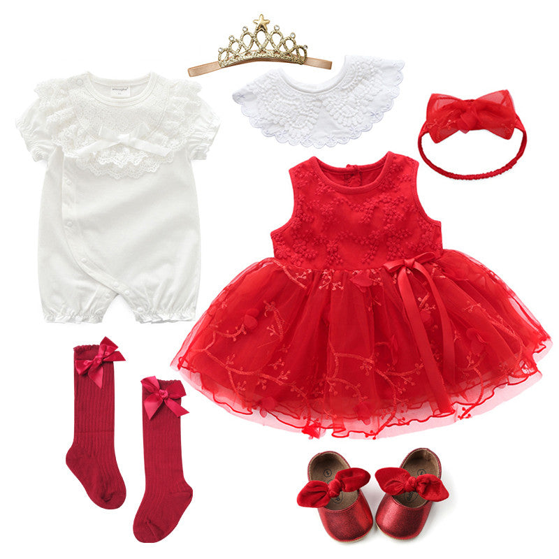 Baby outfit set including a white romper, red dress with floral embroidery, red shoes with bows, matching socks, a lace collar, a red headband, and a gold tiara.
