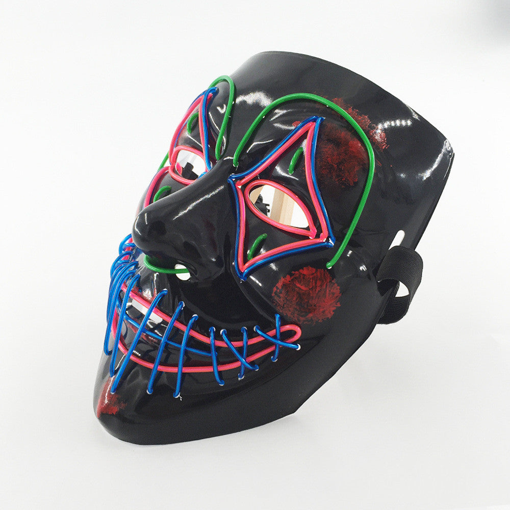 A black mask with colorful neon outlines in red, blue, and green. The design features geometric shapes and a stitched mouth pattern, creating a vivid, striking appearance.