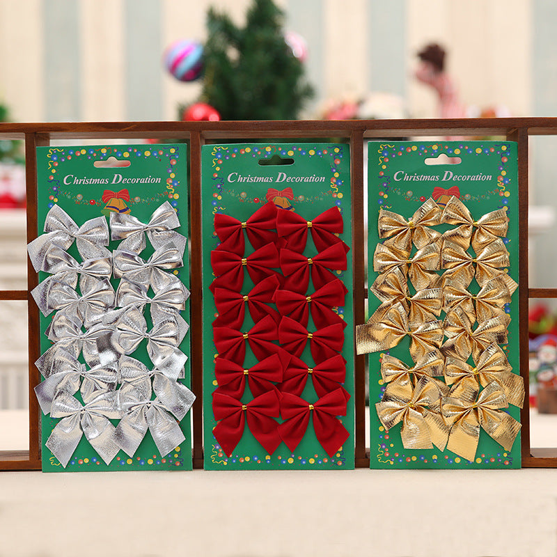 Silver, red, and gold Christmas bows displayed on three green cards labeled "Christmas Decoration," with soft-focus festive background.